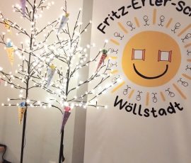 Zuckertütenbäume vor dem Schulbanner im Hintergrund